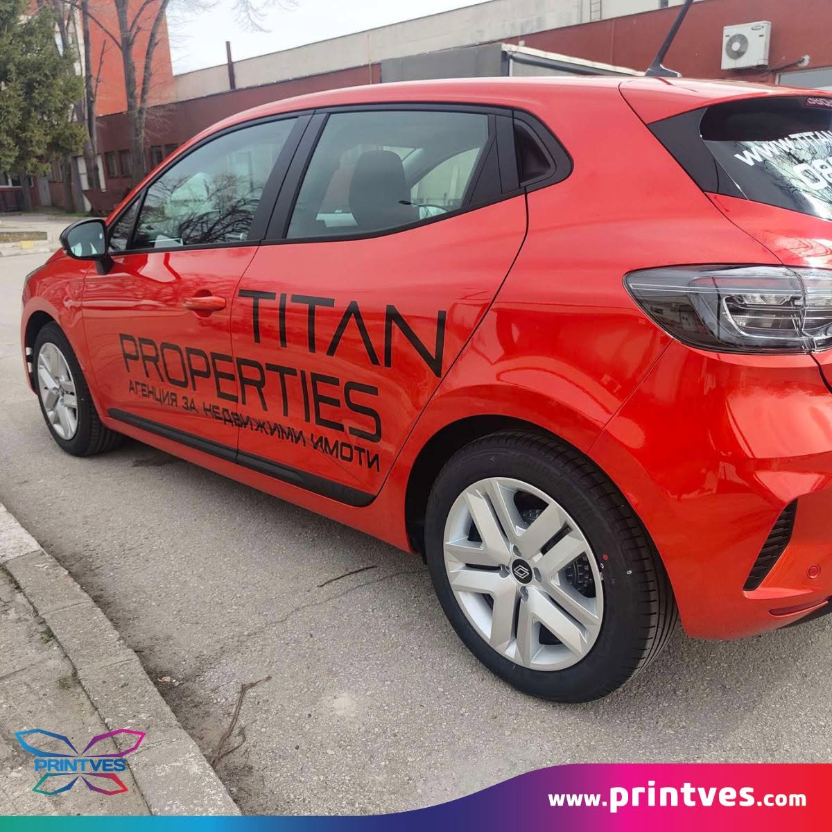 Червен хечбек с надпис TITAN PROPERTIES от фолио на вратите