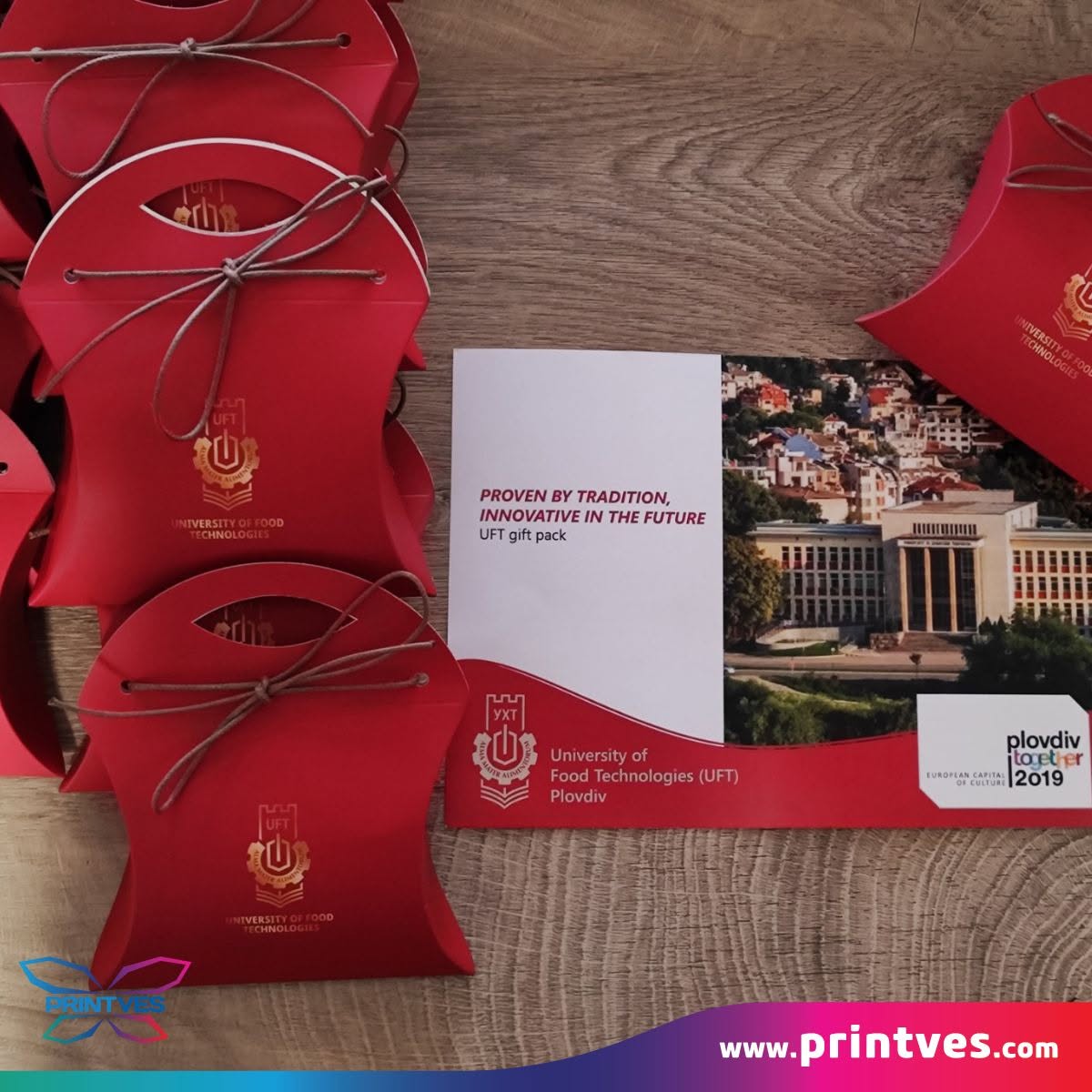 Червени подаръчни кутийки и картичка с лого на университет